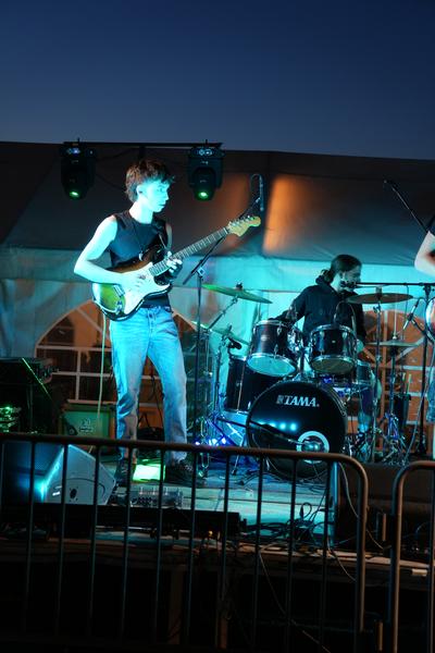 Guitarist under cyan stage lights